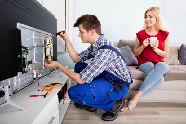 depositphotos 137860252 stock photo technician repairing television at home (4)